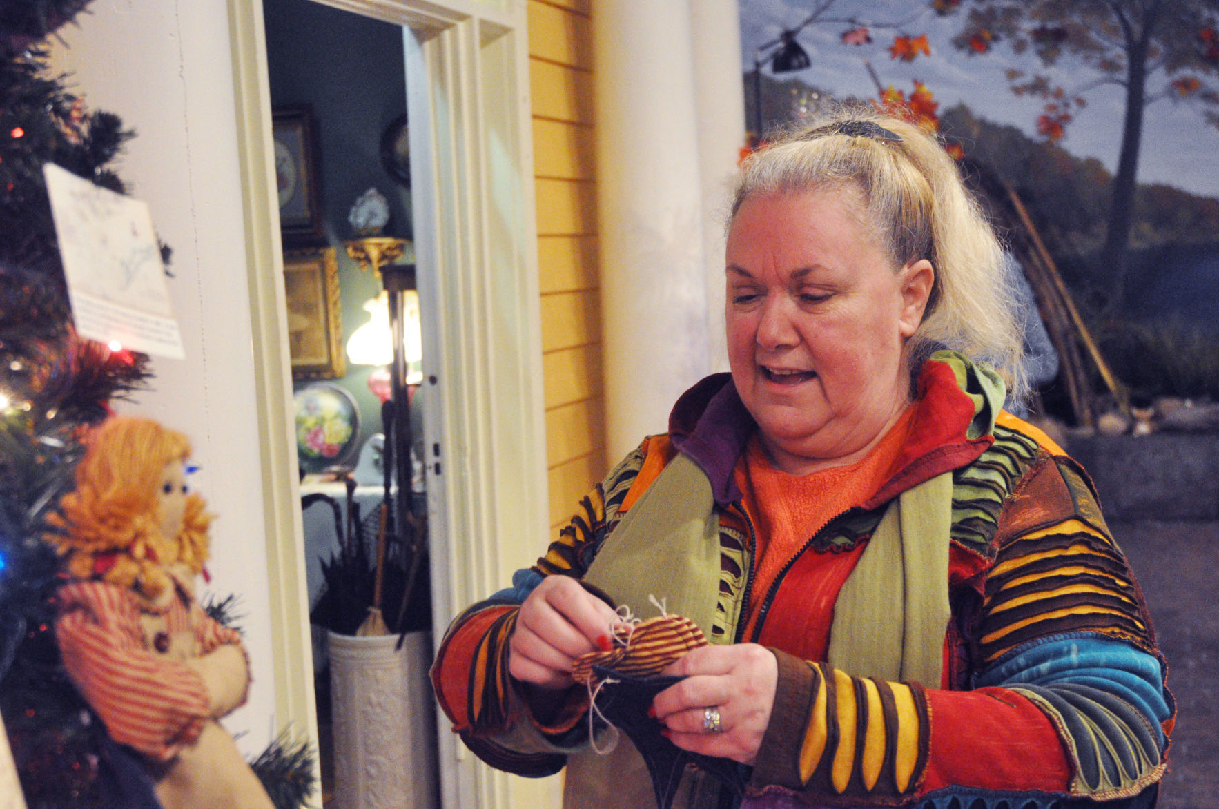 JaNelle Powers, member of the Daughters of the American Revolution, being to place an ornament